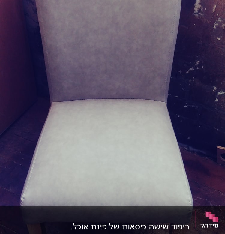 כיסא מרופד בבד אפור על רצפת עץ